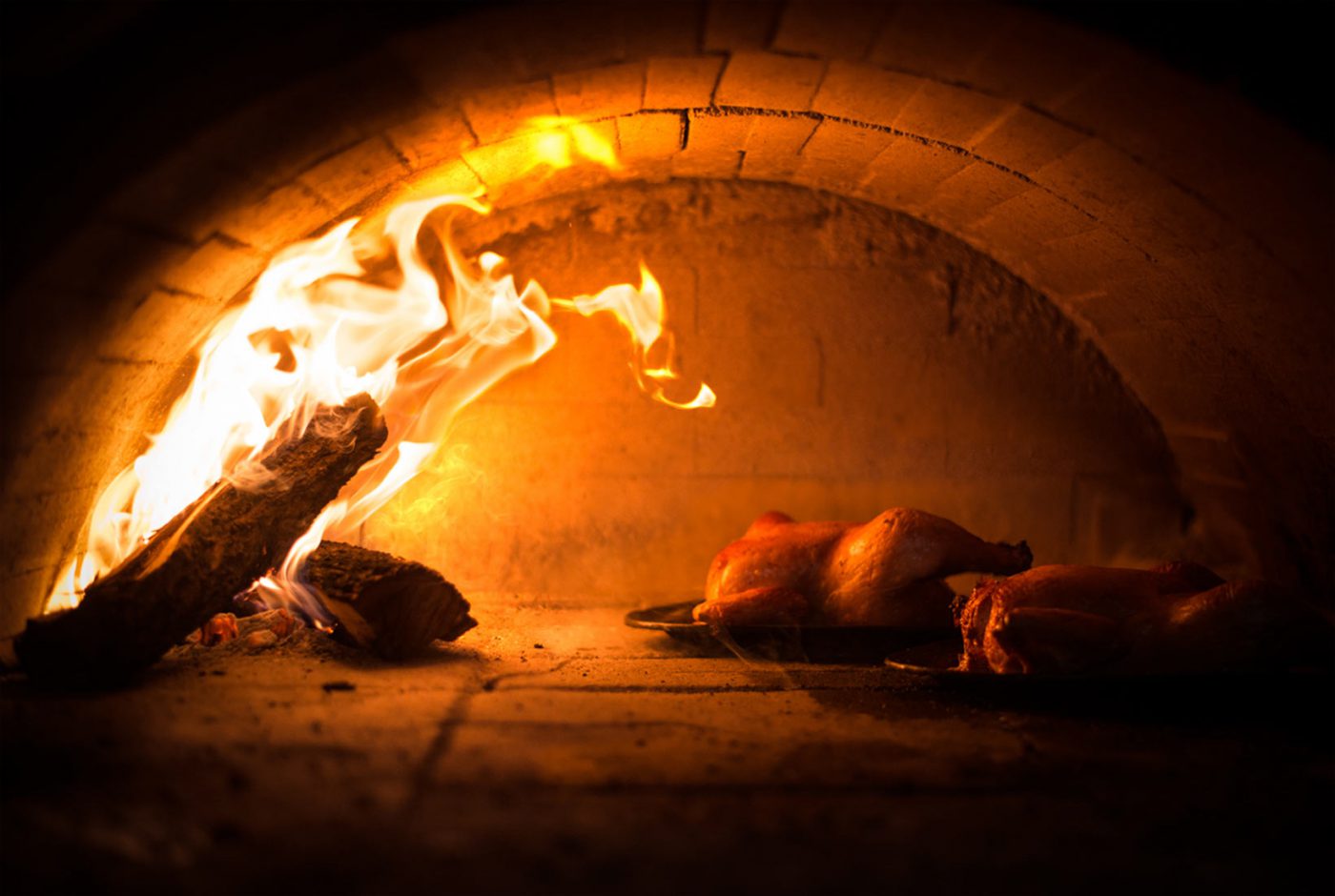 Chickens roasting beside the flames in Zuni's wood-fired brick oven