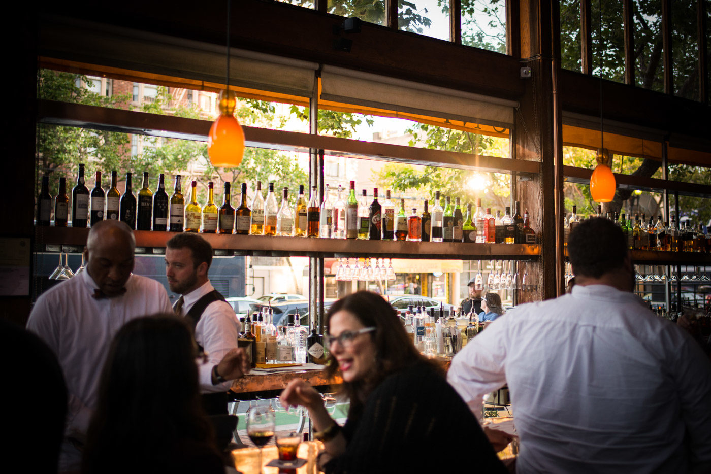 The copper bar at golden hour, bottles backlit by the windows on Market Street